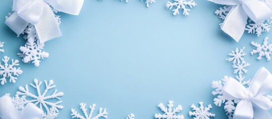Wall Mural - snowflakes and white bows framing an empty space on a soft blue background for winter or holiday the