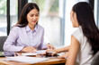 © David - Financial Business two women analyze the graph of the company's performance to create profits and growth, Market research reports and income statistics, Financial and Accounting concept.