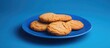 © Cyber Shutter - Freshly baked cookies arranged on a blue plate against a vibrant blue backdrop ideal for cozy kitchen and home decoration themes.