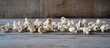 ©  AugmentArt - White popcorn kernels lined up on a rustic wooden surface showcasing a natural snack perfect for movies or gatherings.