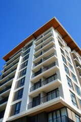 Wall Mural - A stunning modern residential building with expansive balconies against a vibrant blue sky, ideal for showcasing contemporary architecture in promotional materials and marketing campaigns