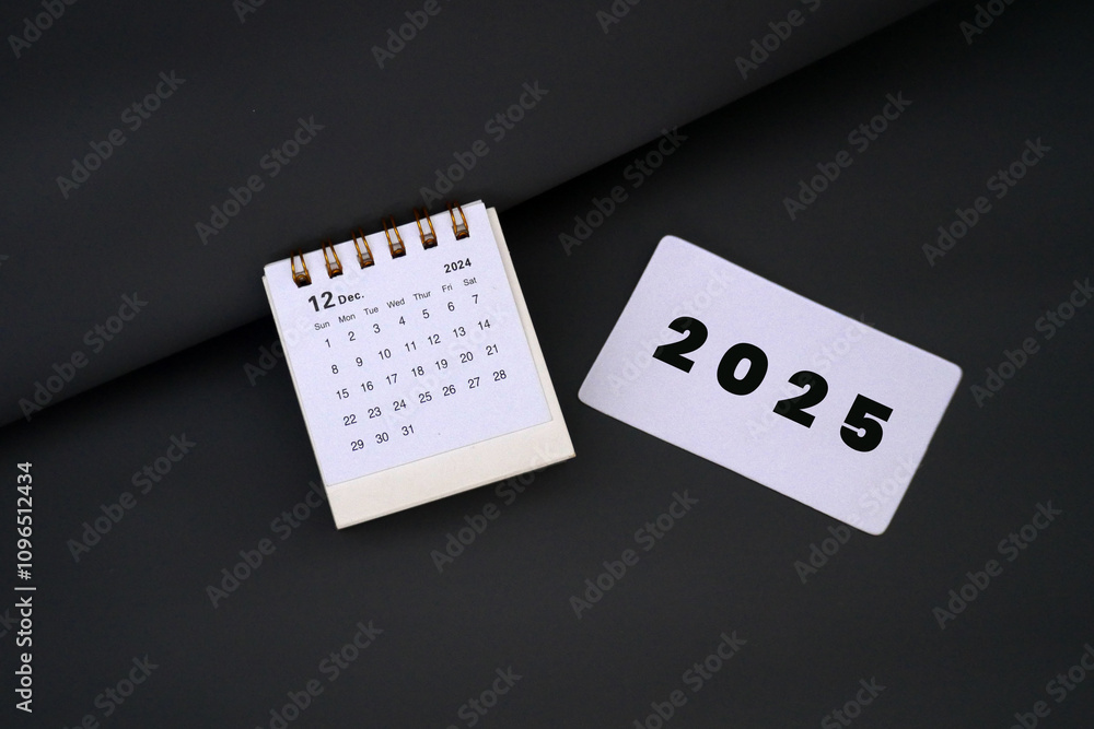 2025 card next to December 2024 desk calendar End of year 2024 concept 2025 card next to December 2024 desk calendar End of year 2024 concept