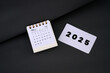 © Ka Iki - 2025 card next to December 2024 desk calendar. End of year 2024 concept.