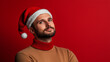 © Mentwint - Editorial Photo portrait of man in Christmas hat, simple red background