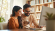 © PRASANNAPIX - couple with a small dog in a home office, modern desk with computer, bookshelves filled with books