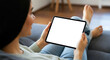 © TAMER YILMAZ - Close up of woman relaxing on couch at home using modern tablet device. Woman resting on couch looking at white blank mock-up screen on tablet device. Technology, communication concept.