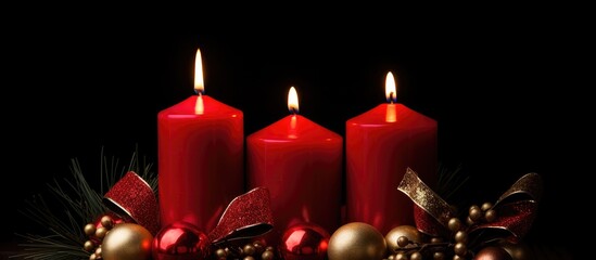 Wall Mural - Festive red Christmas candles with decorations on a dark background creating a warm holiday atmosphere