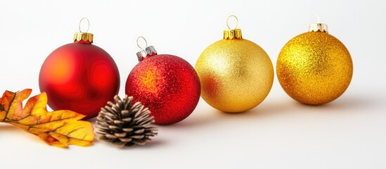 Wall Mural - Festively arranged red and gold Christmas baubles with pine cone and autumn leaves on a white background for holiday decor themes