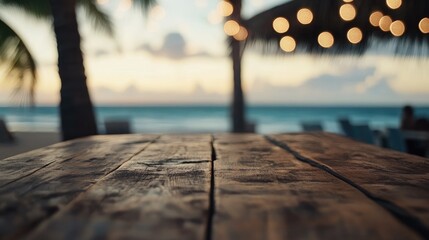 Wall Mural - Rustic wooden table in focus with softly blurred beach cafÃ© ambiance and bokeh lights creating a warm, inviting atmosphere.