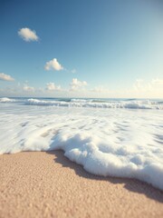 Close-up of foamy waves rolling onto a sandy beach under clear blue skies, beach, vibrant