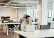 © Rizka - Focused Young Man Working on Laptop in Modern Office
