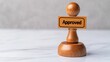 © mangolovemom - A wooden stamp with the word 'Approved' sits on a marble surface, symbolizing validation or endorsement.