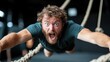 © Pinklife - A man with a shocked expression hangs onto ropes in an indoor obstacle course gym, showcasing surprise and thrill in a vibrant and challenging environment.