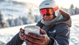 Smiling skier holding hot drink in snowy mountain landscape