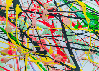 Abstract background made of acrylic latex paint. Green, red, yellow and black spots of flowing splattered paint. Abstract Expressionism.