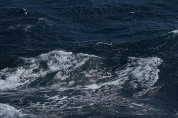 Wall Mural - dark ocean waves crashing with white foam create dramatic seascape. turbulent water reflects power a