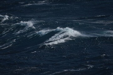 Wall Mural - dark ocean waves crashing with white foam create dramatic seascape. turbulent water showcases power 