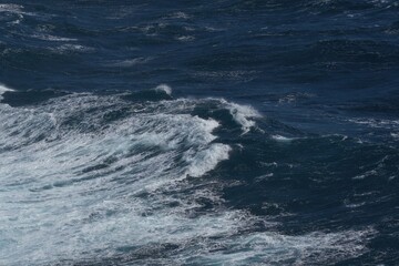 Wall Mural - rough ocean waves create dynamic scene with deep blue water and white foam. powerful movement of sea