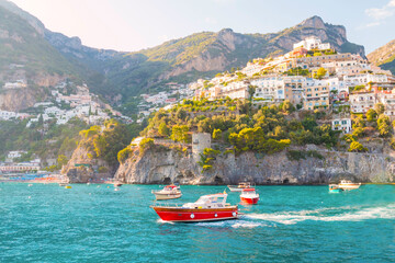 Wall Mural - The photo captures a sunny view of Amalfi, showcasing the town's colorful buildings, steep cliffs, and vibrant coastline under a clear blue sky on a bright day.