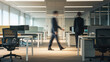 © Tom - A blurred view of a professional office space featuring a male and female colleague engaged in conversation, showcasing teamwork and collaboration.