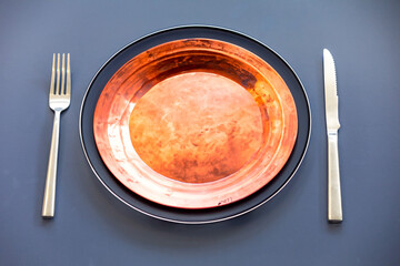 Empty plate top view with metal cutlery next to it