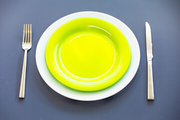 Empty plate top view with metal cutlery next to it