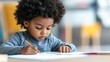 © Alexey - African american child focused on writing or drawing at desk. Elementary school education. Young student doing homework. Learning and development concept with copy space