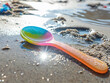 © Jan - A discarded plastic spoon lying on a sunlit beach, symbolising environmental neglect and plastic waste impact.