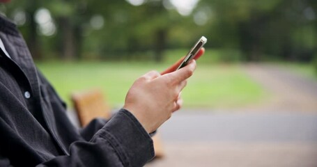 Man, hands and typing with phone on park bench for communication, online chatting or texting in nature. Japanese, closeup or male person on mobile smartphone for network, travel app or location