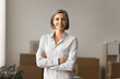 © fizkes - Happy confident grey haired businesswoman posing for portrait in e-commerce storage, looking at camera with folded arms and toothy smile, enjoying work on Internet store project