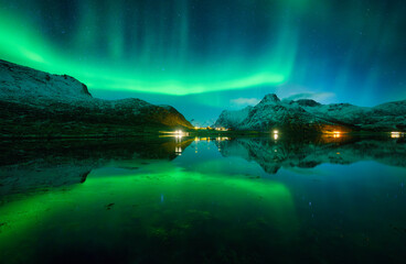 Wall Mural - the aurora borealis illuminates the night starry sky, bathing snowy mountains in a green glow and re
