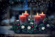 © Maren Winter - Advent wreath with the fourth lit candle and Christmas decoration outdoors in a patio at night in bluish light, snowy bokeh, copy space, colorized photo, selected focus