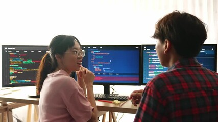 Slow motion back end software developer engineer for computer programming working together on debugging writing computing code, solving complex algorithms display on monitor in office. Burgeoning
