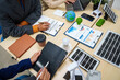 © R Photography - Asian business professionals in collaborate at desk with building models, planning sustainable projects solar panels, electric cars, wind turbines, eco-friendly practices and clean energy solutions.