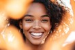 © Milana - Happy woman smiling with gold hoop earrings surrounded by autumn leaves in heart shape - Joyful black woman outdoor portrait - Self love and wellness concept
