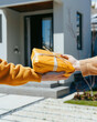 © Nakorn - Package delivery action at customer doorstep closeup content residential area clean viewpoint vibrant concept for online shopping