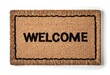 © MdAli - Stylish door mat with word Welcome on wooden floor, top view