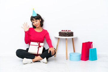 Young girl celebrating his birthday sitting on the floor isolated on white background counting five with fingers