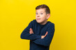 © luismolinero - Little caucasian boy isolated on yellow background making doubts gesture while lifting the shoulders