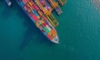 © Pumapala - Aerial view of a cargo ship loaded with colorful containers in clear blue water.