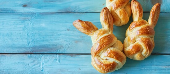 Canvas Print - Baked Easter bunny shaped puff pastries with cinnamon on a rustic blue wooden table festive holiday baking inspiration.