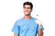 © luismolinero - Young dentist man holding tools over isolated background thinking an idea while looking up