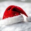 © Kavita - Santa's hat resting on a snowy surface white background