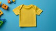© ANGEL4289 - A bright yellow toddler shirt displayed on a blue background, surrounded by colorful toys, creating a playful and vibrant atmosphere.