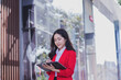 © NANKHAMMAI - A businesswoman working on a tablet walks on the street in Lae city, talking on the phone with a friend.
