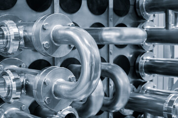 Poster - Dairy machine cooling radiator with a row of stainless steel metal pipes with silver trim. The pipes are connected to each other and appear to be part of a larger system