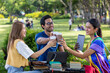 © Akarawut - Group of diverse college student is meeting and working on thesis and project outside in the university campus garden during summer