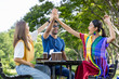 © Akarawut - Group of diversity college student is meeting and working on thesis and project outside in the university campus garden during summer