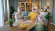 © Miljan Živković - Group of people senior man and women play leisure board game at home