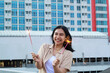 © M Alfan Setyawan - excited asian young woman holding sparkler to celebrating new year eve in rooftop apartment with city building background